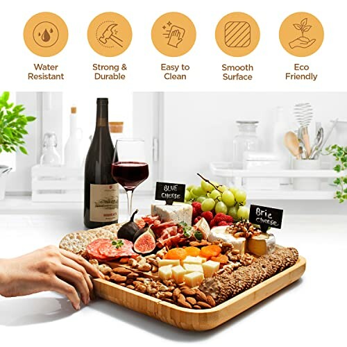 Bamboo charcuterie board with wine, cheese, and fruits on a kitchen counter.