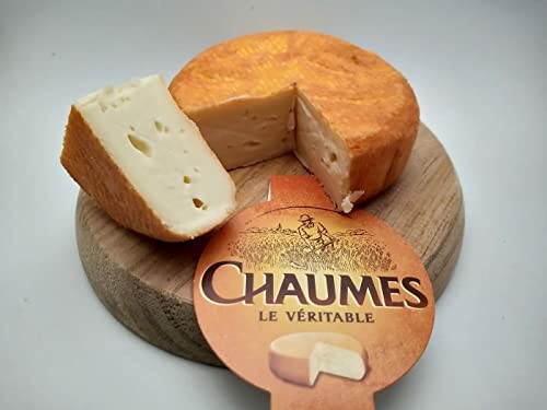 Chaumes cheese wheel on wooden board with cut slices