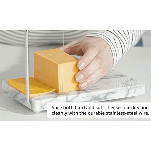 Person using a cheese slicer on a marble board.