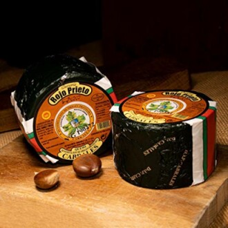 Two blocks of Rojo Prieto cheese on a wooden surface with two nuts.